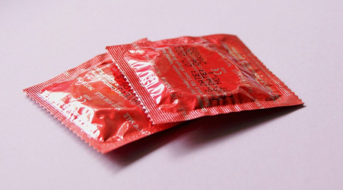 Røde kondomer ligger på hvidt bord